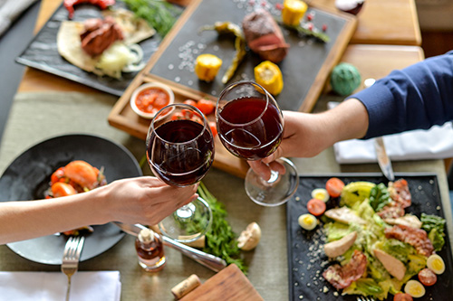 couple trinquant au cours d’un repas