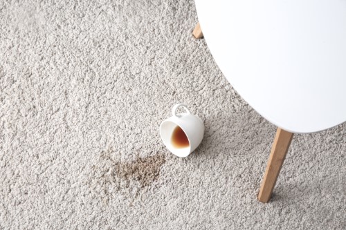 tasse de café renversée sur un tapis beige